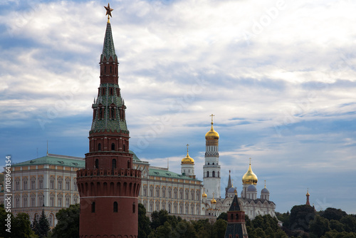 Moscow Kremlin, featuring a red-brick tower with a green spire topped by a red star, alongside golden-domed churches and cathedrals