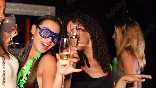 Young women celebrating at a vibrant party with drinks in hand. photo