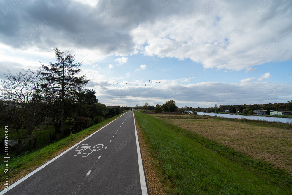 Fototapeta premium Scenic Bicycle Path in Rural Countryside under Cloudy Skies