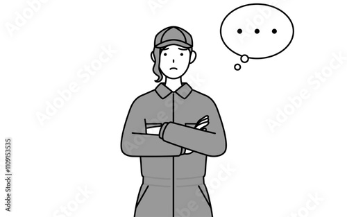 腕を組んで考えるつなぎ姿の女性整備士