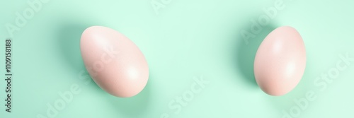 Two pale eggs positioned on a light green surface representing simplicity in minimalistic design photo