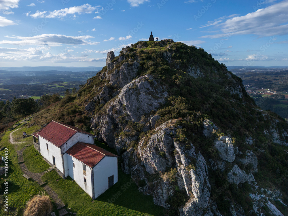 Naklejka premium Aerial view of the Pico Sacro mountain and the Chapel of San Sebastian del Pico Sacro in Boqueixon, Galicia