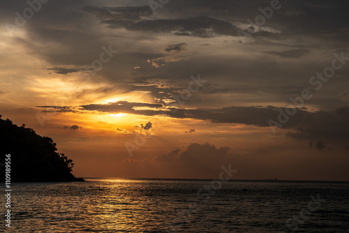 The sky is dark and cloudy, and the sun is setting