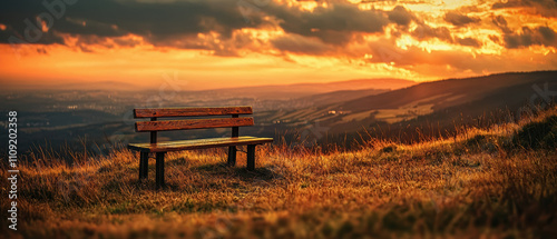 serene wooden bench on hilltop at sunset, surrounded by golden grass and breathtaking landscape. warm colors evoke sense of peace and tranquility