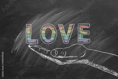 A chalkboard design features the word LOVE in rainbow letters, resting delicately on a sketched hand. LGBT, LGBTQIA rights and gender equality concept. Pride month. Declaration of love