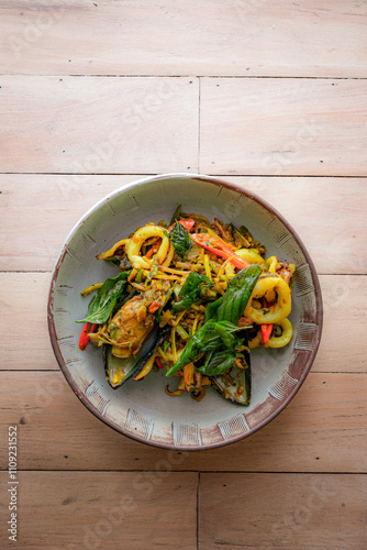 Top view of stir-fried seafood with spicy thai herbs, include with mussels, shrimps and squids