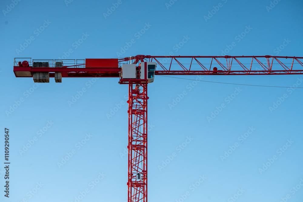 Huge red crane at construction site, against a beautiful blue sky. Huge red crane at construction site, against a beautiful blue sky.