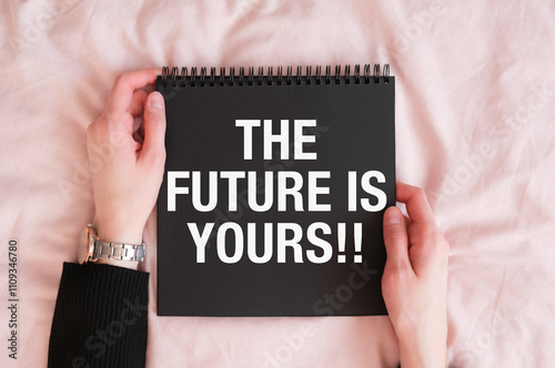 The Future Is Yours text hold by woman on pink background photo