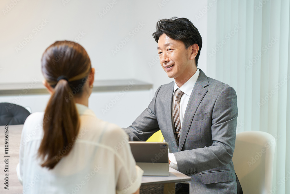 Fototapeta premium 女性に向かって話すスーツ姿の男性