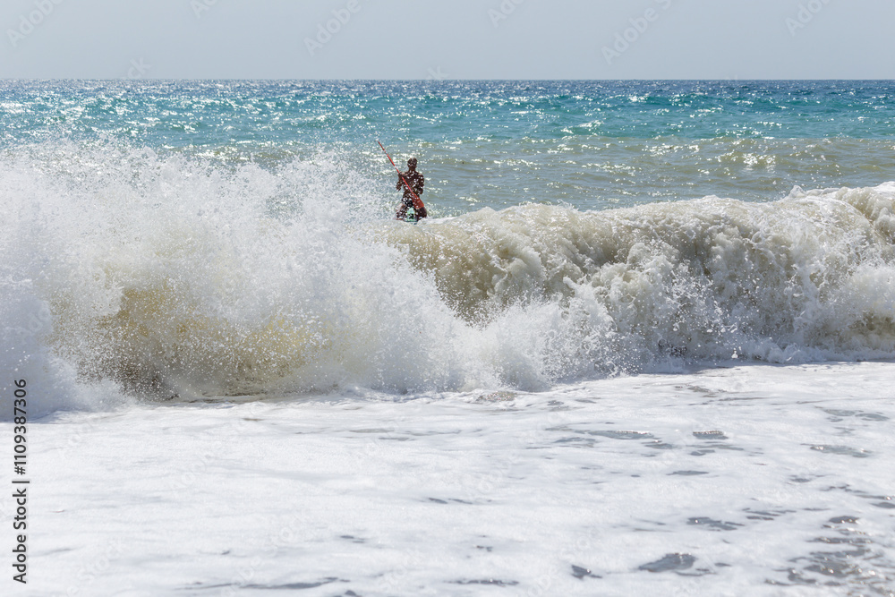 Naklejka premium Man surfing in sea against clear sky