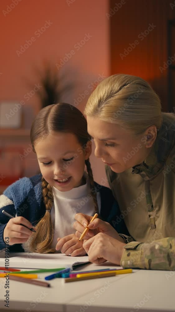 Soldier mom and her cute daughter draw together, sharing joyful family moments Soldier mom and her cute daughter draw together, sharing joyful family moments