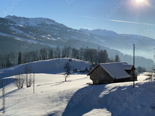 Old traditional swiss rural architecture and alpine livestock farms in the winter ambience over the Lake Walen or Lake Walenstadt (Walensee) and in Swiss Alps, Walenstadtberg - Switzerland (Schweiz) photo