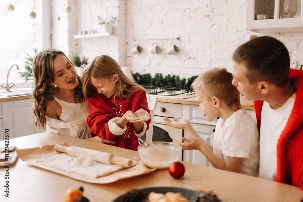 A family with two teenage children is preparing for the Christmas holiday, cooking and laughing together in the kitchen at home in winter in December. Selective focus A family with two teenage children is preparing for the Christmas holiday, cooking and laughing together in the kitchen at home in winter in December. Selective focus