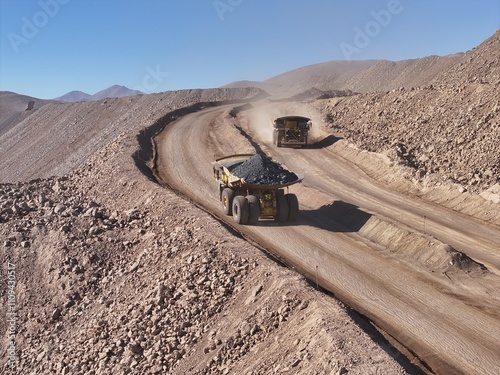 Heavy Haul Trucks Transporting Copper Ore Through the Desert at an Open-Pit Mine in Chile - High-Tonnage Mining Operations in a Rugged Landscape