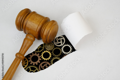 Legal proceeding  concept. Judge gavel on paper with many connected gears under.  photo