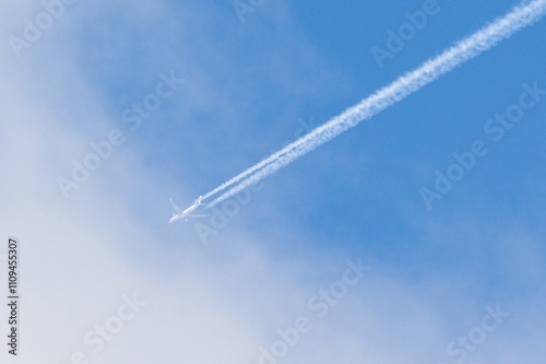 Transport airplane makes the very strong trace line of chemtrails on blue sky. Conspiracy theory.
