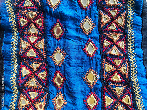 Kutchi Bharat embroidery showcasing intricate triangular patterns, highlighted by a beige thread border on luxurious blue raw silk