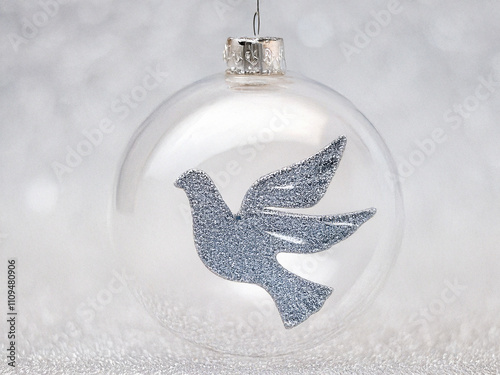 Christmas bauble made of satinized glass with lots of silver grains. A dove of peace on the bauble. photo