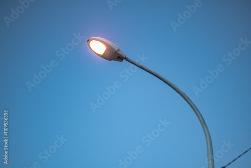 Indonesia, October 5, 2024 - burning Street lamp with a fiery glow and a beautiful blue sky as background