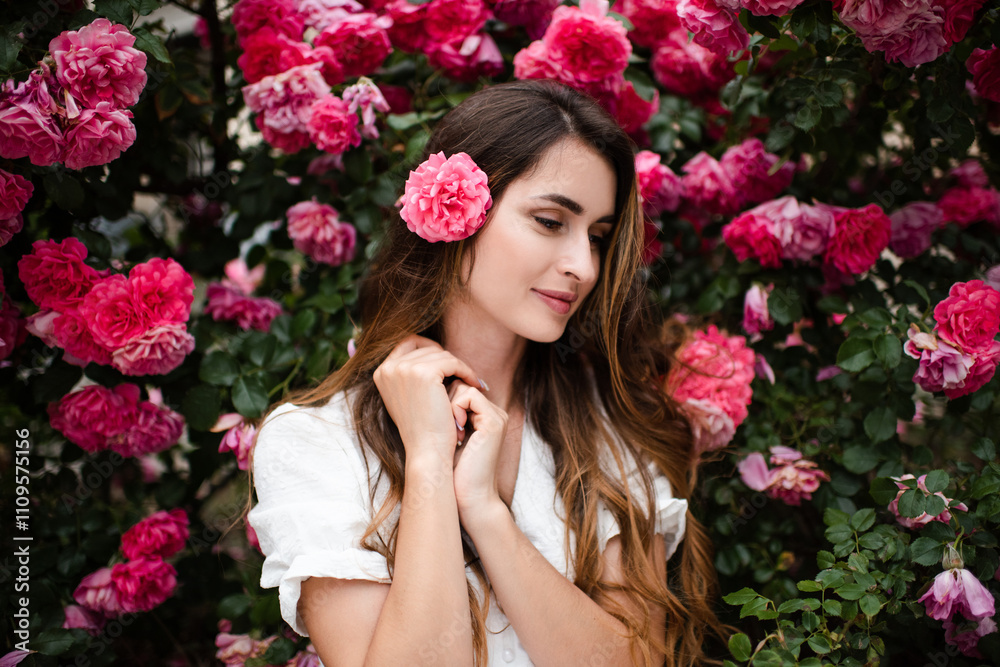 Beautiful young woman 25-29 year old with long blonde hair posing with pink rose flowers in garden outdoors. Springtime. Beautiful young woman 25-29 year old with long blonde hair posing with pink rose flowers in garden outdoors. Springtime.