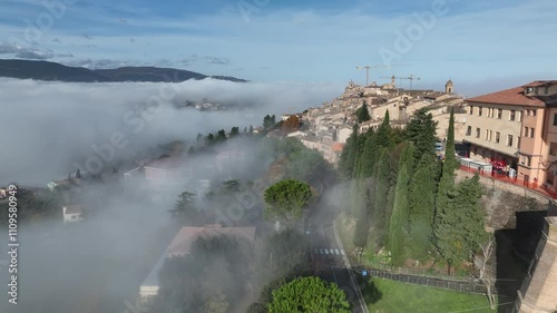 Fog envelops hillside view in ancient town during early morning hours