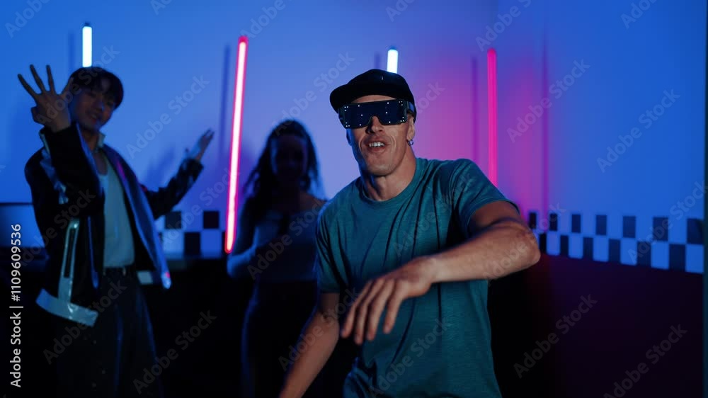 Skilled break dancer dancing in front of camera while diverse friend moving to pop or hip hop music behind. Attractive performer team taking turn to perform energetic movement at camera. Regalement. Skilled break dancer dancing in front of camera while diverse friend moving to pop or hip hop music behind. Attractive performer team taking turn to perform energetic movement at camera. Regalement.