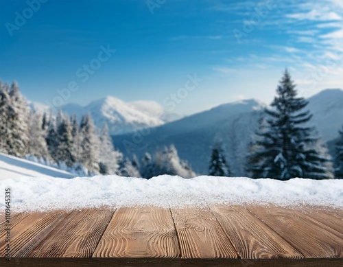 empty wooden table top coverd with snow with copy space and winter snowing trees and mountain background photo