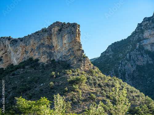 Rocky outcrop with horizontal striped structure, silhouetted against an intensely blue sky