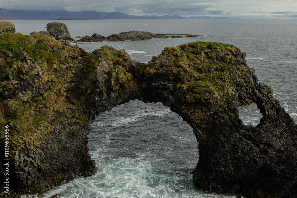 Fototapeta premium Aerial view of a lava rock arch in the sea off the coast of Iceland