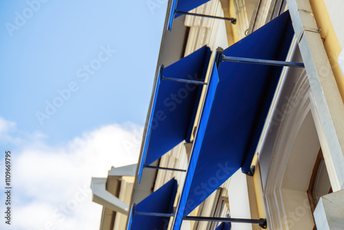 Wallpaper Mural retractable blue fabric awnings adorning windows, creating a vibrant contrast against the building's facade, enhancing both aesthetics and functionality Torontodigital.ca
