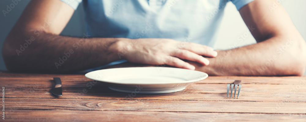 man hands holding fork and knife over the empty plate man hands holding fork and knife over the empty plate