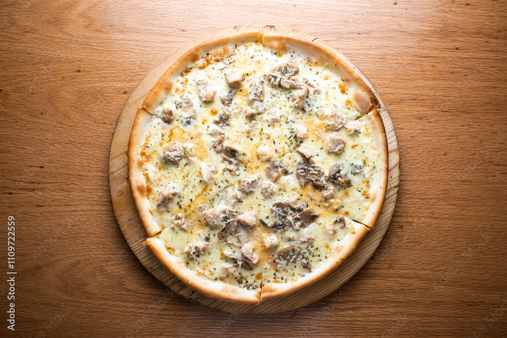 Chicken Mushroom Alfredo Pizza topped with creamy sauce and melted cheese served on wooden board isolated on table background top view of italian cousin