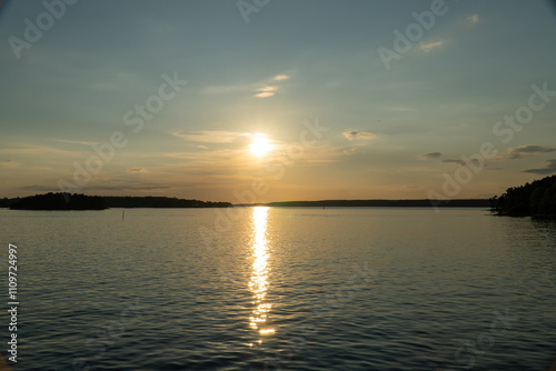 The setting sun over the bay among the forests and lakes