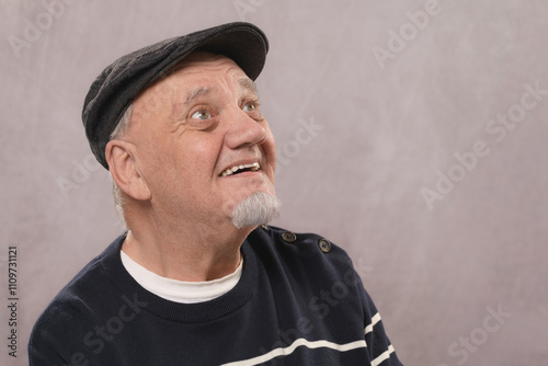 portrait homme âgé souriant sur fond gris