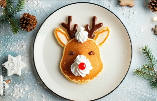 Christmas baby pancakes in the shape of a deer with whipped cream on a festive background, top view photo