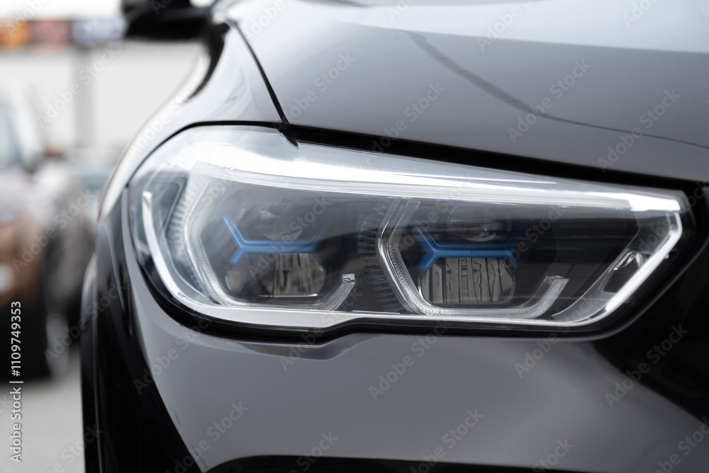 Fototapeta premium black car headlight, close up view, car dealing and manufacturing, cropped car image
