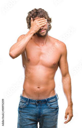 Handsome hispanic model man sexy and shirtless over isolated background smiling and laughing with hand on face covering eyes for surprise. Blind concept.