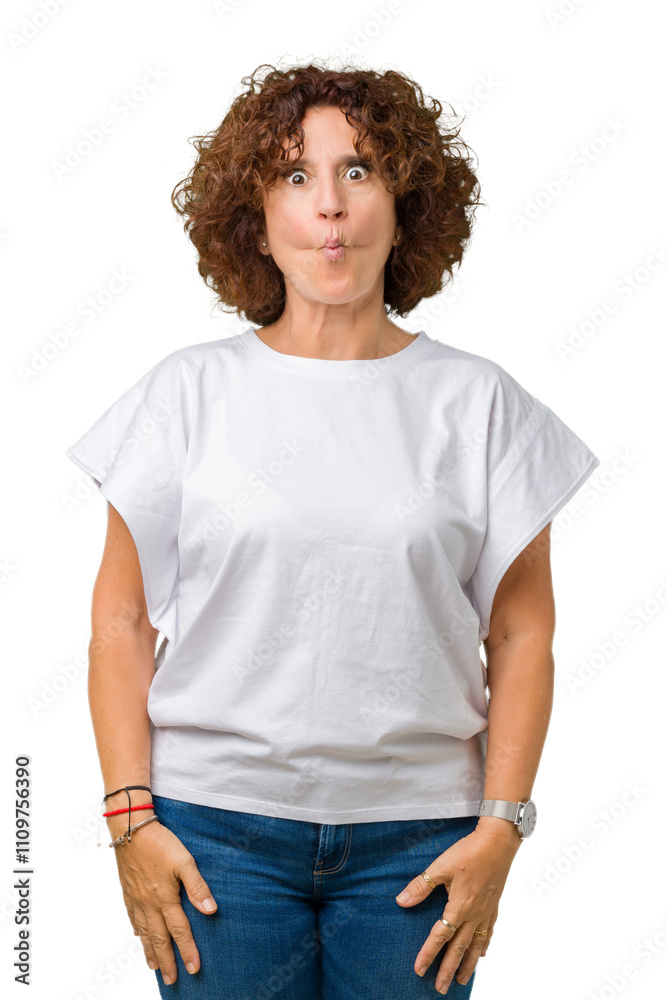 Beautiful middle ager senior woman wearing white t-shirt over isolated background making fish face with lips, crazy and comical gesture. Funny expression. Beautiful middle ager senior woman wearing white t-shirt over isolated background making fish face with lips, crazy and comical gesture. Funny expression.