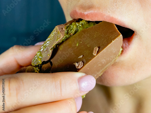 Girl eating Dubai chocolate with pistachio paste and kataifi dough. photo