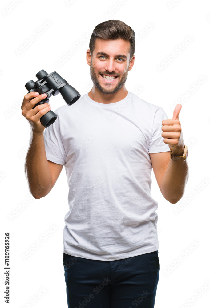 Young handsome man looking through binoculars over isolated background happy with big smile doing ok sign, thumb up with fingers, excellent sign Young handsome man looking through binoculars over isolated background happy with big smile doing ok sign, thumb up with fingers, excellent sign