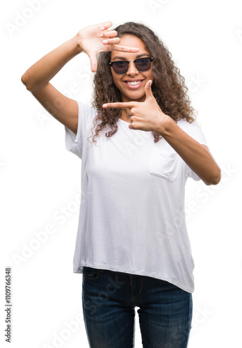 Young hispanic woman wearing sunglasses smiling making frame with hands and fingers with happy face. Creativity and photography concept.