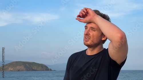 Young man suffering from heat, high temperature, hot weather. Dangerous sun, sunstroke