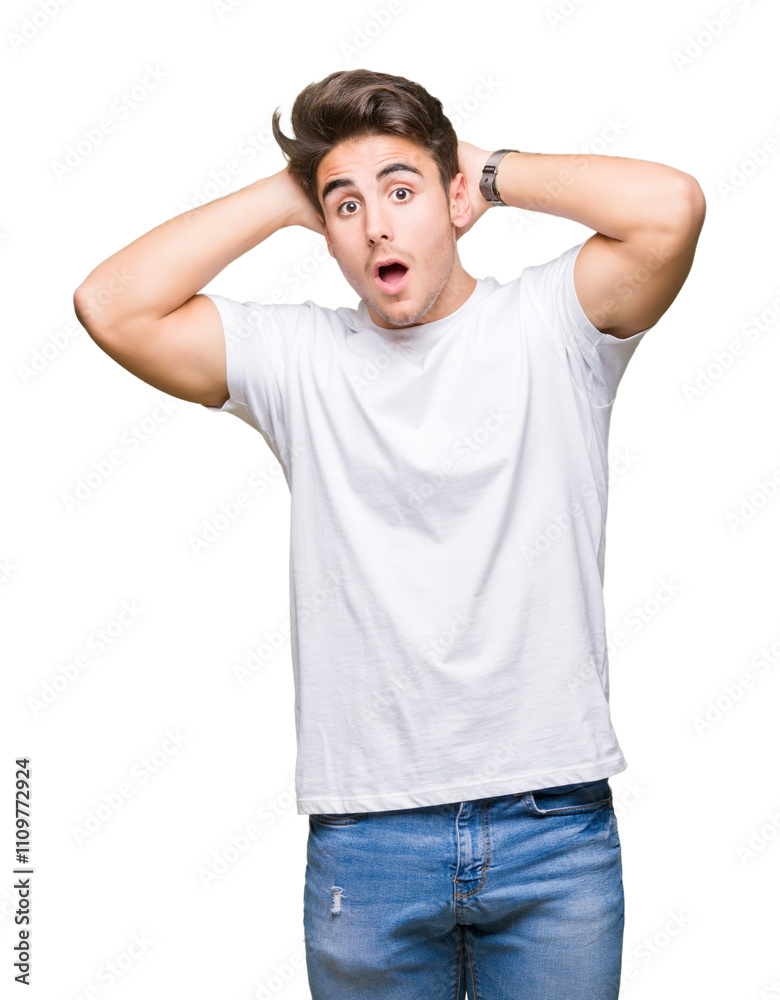 Young handsome man wearing white t-shirt over isolated background Crazy and scared with hands on head, afraid and surprised of shock with open mouth Young handsome man wearing white t-shirt over isolated background Crazy and scared with hands on head, afraid and surprised of shock with open mouth