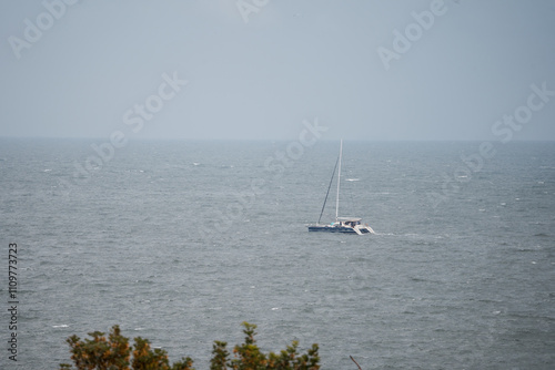 A solitary ship sails in the distance on the vast expanse of the Black Sea, its silhouette faintly visible against the horizon.  photo