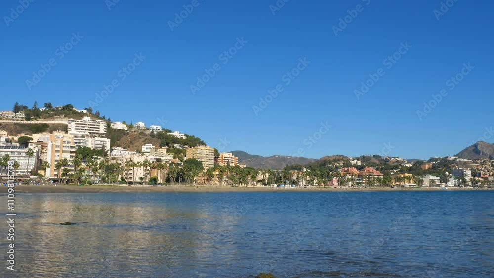 View of Malaga, Spain, featuring the port with cruise ships, industrial cranes, and the cityscape. Green parks and mountains are visible under a clear blue sky, urban and coastal scenery. View of Malaga, Spain, featuring the port with cruise ships, industrial cranes, and the cityscape. Green parks and mountains are visible under a clear blue sky, urban and coastal scenery.