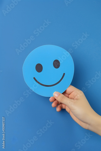 Hand holding blue smiley faec. Happiness concept, good review. High quality photo photo