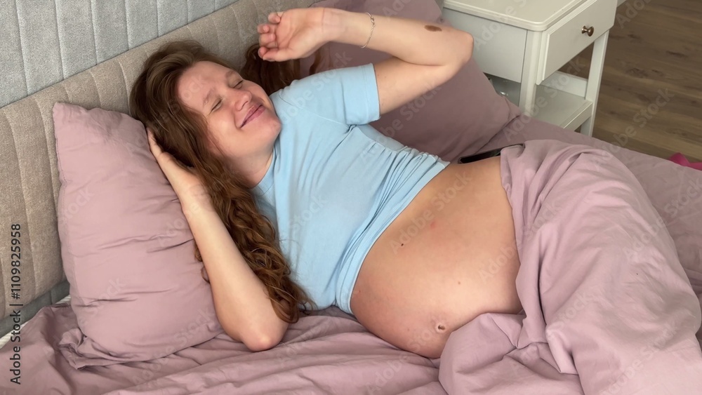 beautiful pregnant woman wakes up and strokes her belly, 3 trimester beautiful pregnant woman wakes up and strokes her belly, 3 trimester