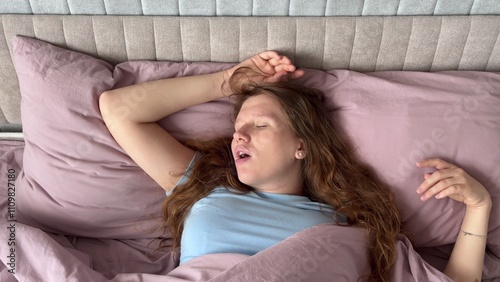beautiful young woman snoring in her sleep in bed, concept apnea, snoring, disorder