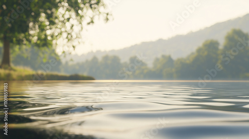 Morning fog over the calm surface of the lake water, soft light with a blurred coastline in the background