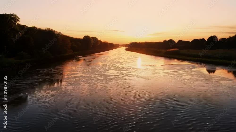 Tranquil river at sunset reflecting warm hues and surrounding nature. Tranquil river at sunset reflecting warm hues and surrounding nature.